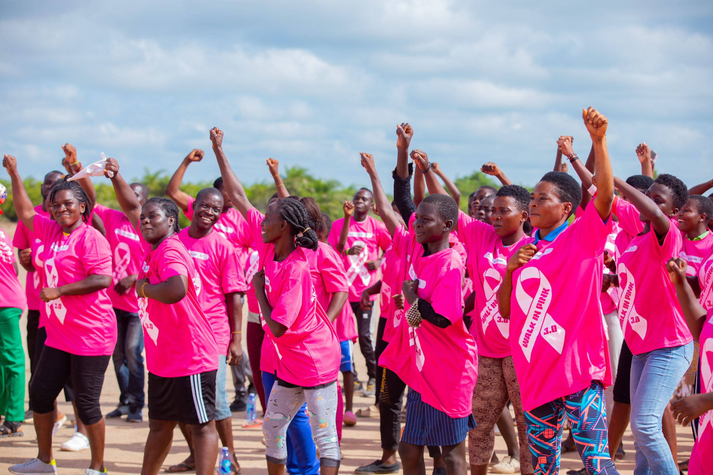 Walk In Pink participants raising their fists in celebration